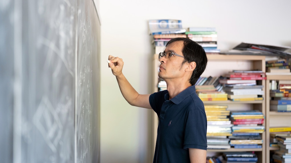 A portrait of Terry Tao near a chalkboard, taken at UCLA.