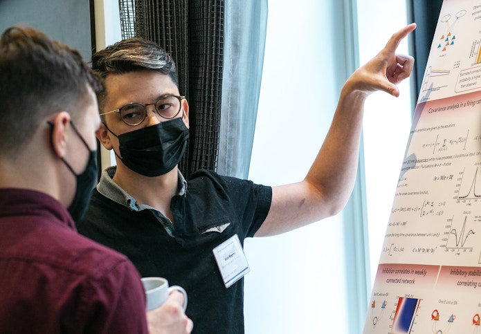 A photo of Alex Negrón, wearing a COVID-19 mask, presenting his poster at the SURFiN Symposium.