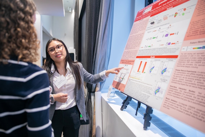 A photo of Faith Cerbo presenting her poster at the SURFiN Symposium.
