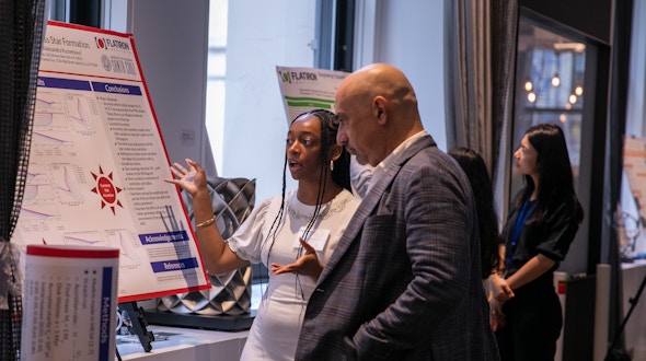 Woman explains poster to a man in a suit.
