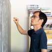 A portrait of Terry Tao near a chalkboard, taken at UCLA.